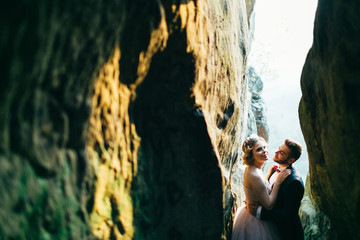 Delighted newlyweds cuddling in the rock shelter