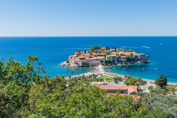 Fototapeta na wymiar View of the island of Sveti Stefan from the hill on a sunny day.