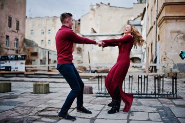 Young beautiful stylish fashion couple in a red dress in love story at the old city