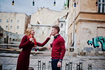 Obraz na płótnie Canvas Young beautiful stylish fashion couple in a red dress in love story at the old city