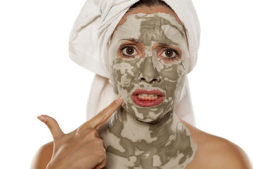 beautiful nervous woman with a mud mask on her face
