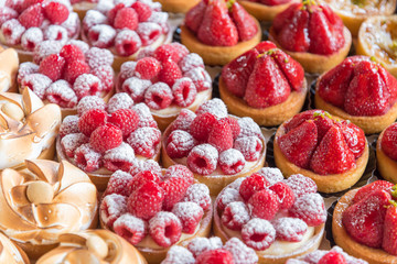 An assortment of mini cakes with berries at Borough Market in London, UK