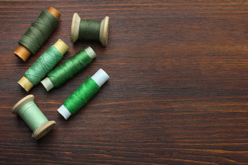 Spool of thread on wooden brown background
