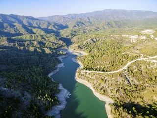 Aerial view of Diarizos river in Paphos, Cyprus. The river cutting through the green valley and lush forest of laona mountain leading to the Venetian bridge from the Arminou reservoir.