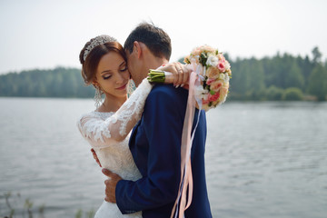 Bride and groom hugging on the shore of Lake