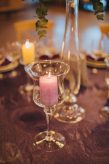 Wedding. At the banquet table are candles and a vase with flower arrangements