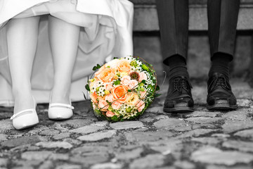 Bridal couple sitting on a stone bench outdoors