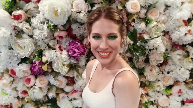 Beautiful girl on the background of flowers in slow motion