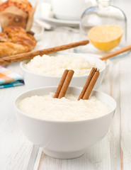 brimming bowls of rice pudding, on wood
