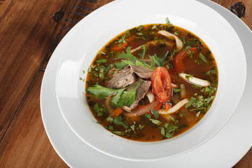 Lamian (Lagman) - traditional asian soup with noodles in a plate. wooden background
