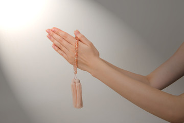 数珠を持ち祈る女性