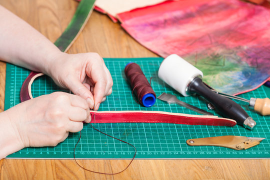 craftsman makes leather belt for new embossed bag