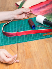 craftsman sews new belt for leather bag