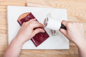 craftsman corrects embossing of leather pouch