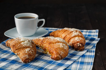 Breakfast with coffee crema, milk, fresh croissants on vintage o