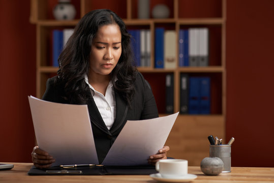 Indonesian female business executive working with papers in office