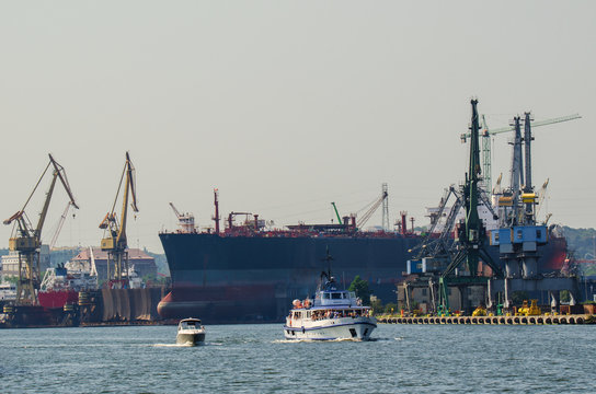 GDANSK SHIPYARD. Built ship dock and cranes at the Gdansk shipyard. Ship walking on the background of the shipyard