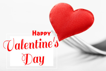 Fork with red heart on white background. Text happy valentines day.