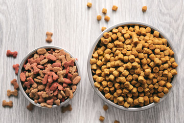 Dog food in bowls on wooden table