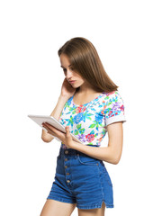 Funny young girl with a tablet isolated on white background.