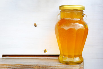 Bottle with honey on beehive background