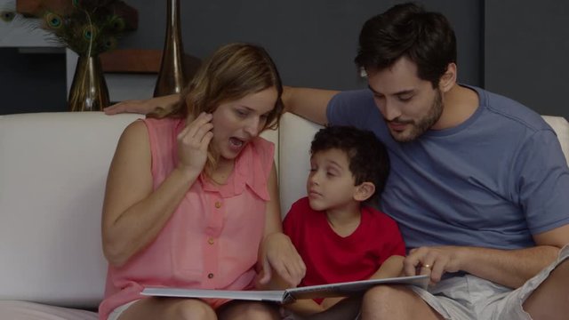 Young couple reading book to son