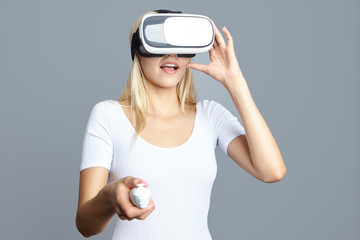 Color shot of a young woman looking through some VR glasses, a d