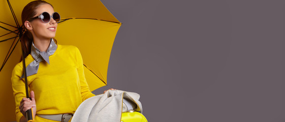 Fashion  woman with yellow umbrella and suitcase. banner concept