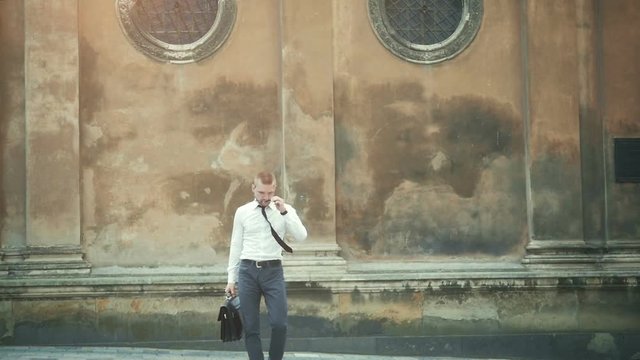 going business man holding brief case over wite in street