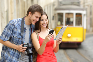 Couple of tourists consulting guide online - obrazy, fototapety, plakaty