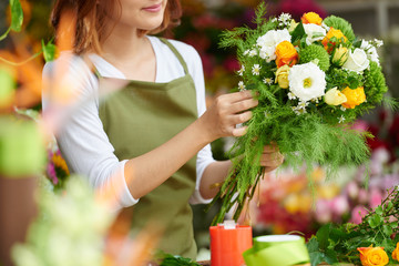 Cropped image of florist making bouquet for client - obrazy, fototapety, plakaty