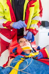 Rettungssanitäter prüfen in einem Rettungswagen die Pupillenreflexe einer Patientin