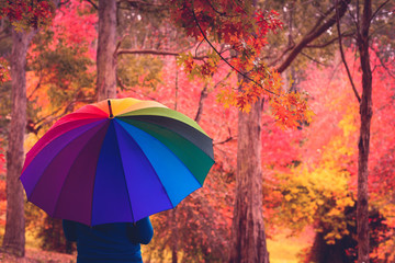 Woman standing under colorful umbrella