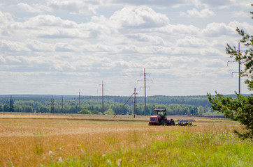 Fototapeta na wymiar Трактор на пшеничном поле