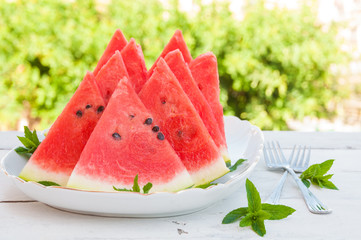 Slices of watermelon in a plate on wooden table