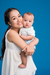 Happy young mother holding her little son