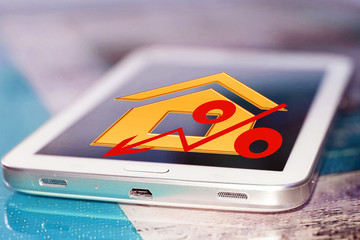 Red percentage sign and house on your phone screen . The concept of online rating of real estate .