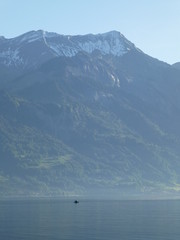 Early morning shot of lone kayaker on Brienzersee lake, Switzerland dominated by the magnificent Brienzer Rothorn mountain 