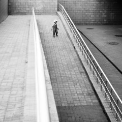 Lone child on city street. Silhouette of little girl on ramp. Black and white photo