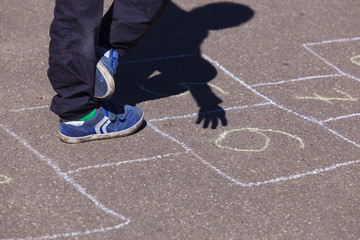 kid playing hopscotch on playground, children outdoor activities