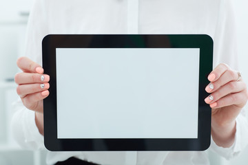 Female hands holding tablet closeup. Tablet with empty space for advertising.