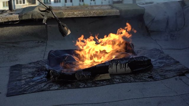 Roofer melts the bitumen