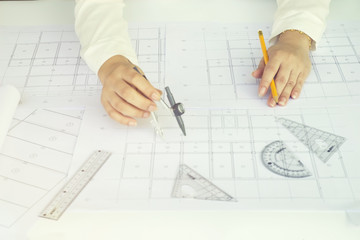 Close up Architect working on blueprint. Architects workplace , architectural  working of Architect sketching a construction project on his plane project. Construction concept