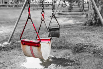 Close up old red swing at playground . selective red color effect with monochrome background .
Shallow depth of field .
copy space for message concept .
background for inspirational quote.