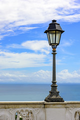 Urban Lampposts on ancient wall with the sea in the background in the city of Salvador, Bahia