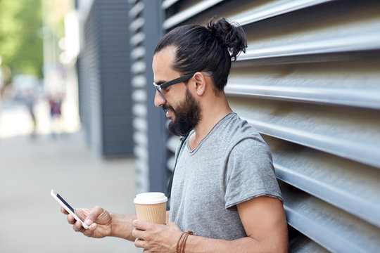 Man With Coffee Texting On Smartphone In City