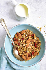 Homemade organic granola with almond and goji berries  on grey concrete texture background.