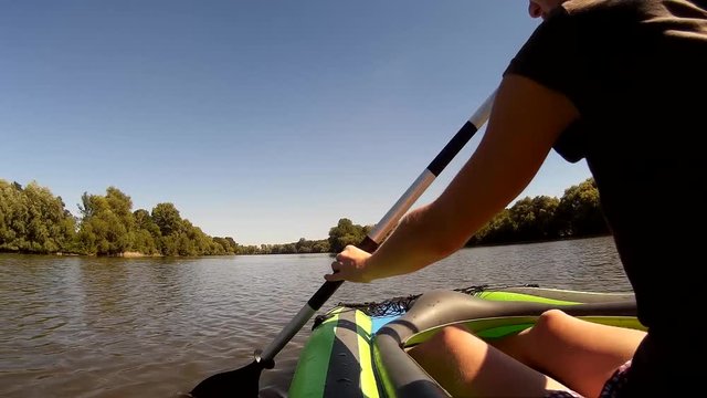 Young girl rowing in a kayak. Ukraine, Southern Bug river. Side view