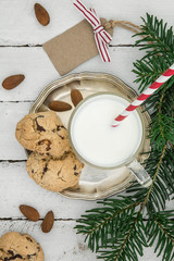 Fototapeta na wymiar Plätzchen und Milch auf einem alten Holzuntergrund - weihnachtliche Stimmung