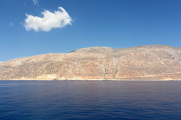 Little cloud on a large mountain in a tranquil and beautiful sea